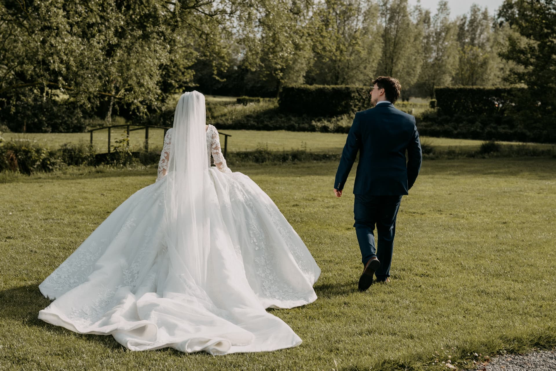 Les mariés se promènent dans le parc, la robe à traîne