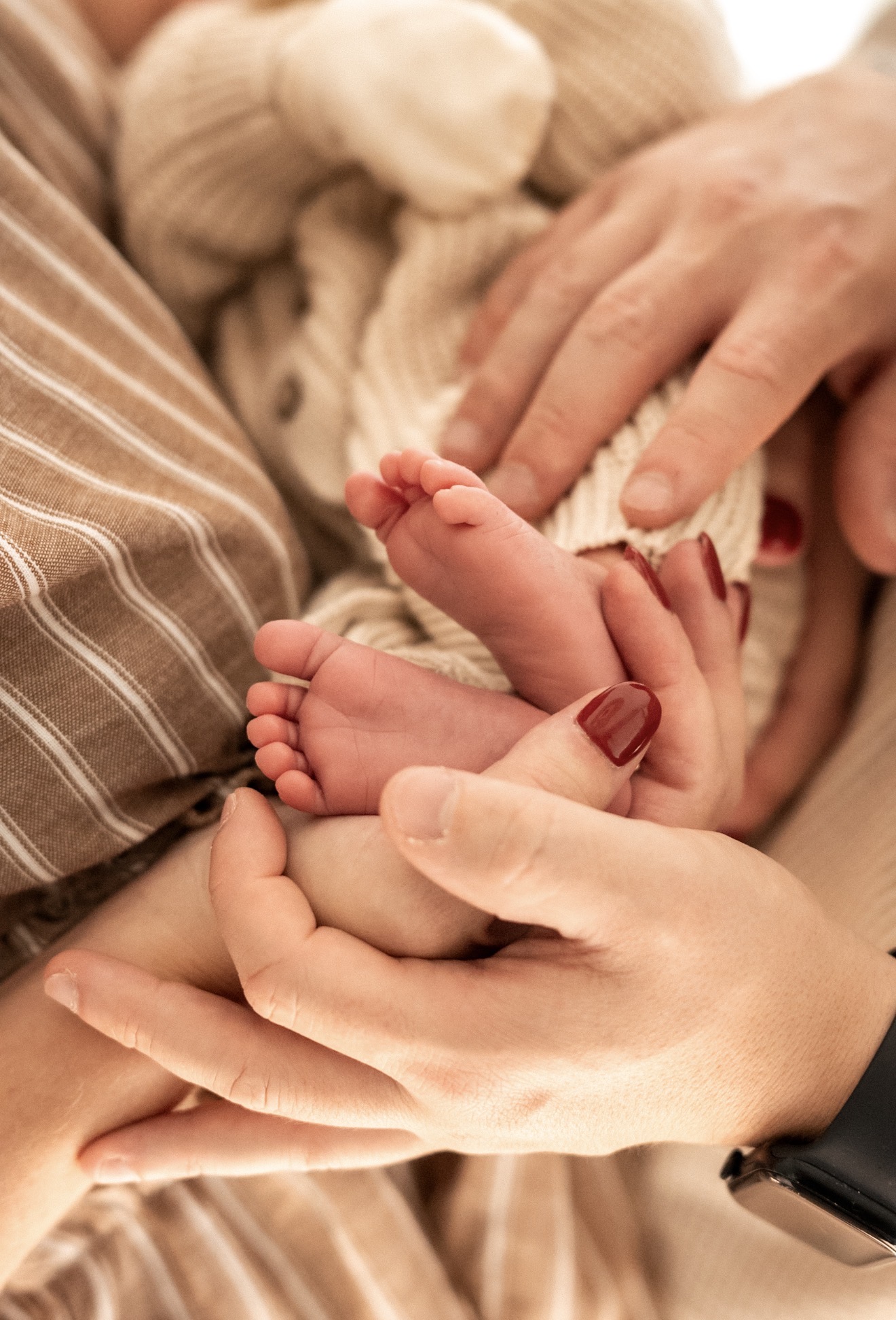 Petits pieds de bébé dans les mains de ses parents