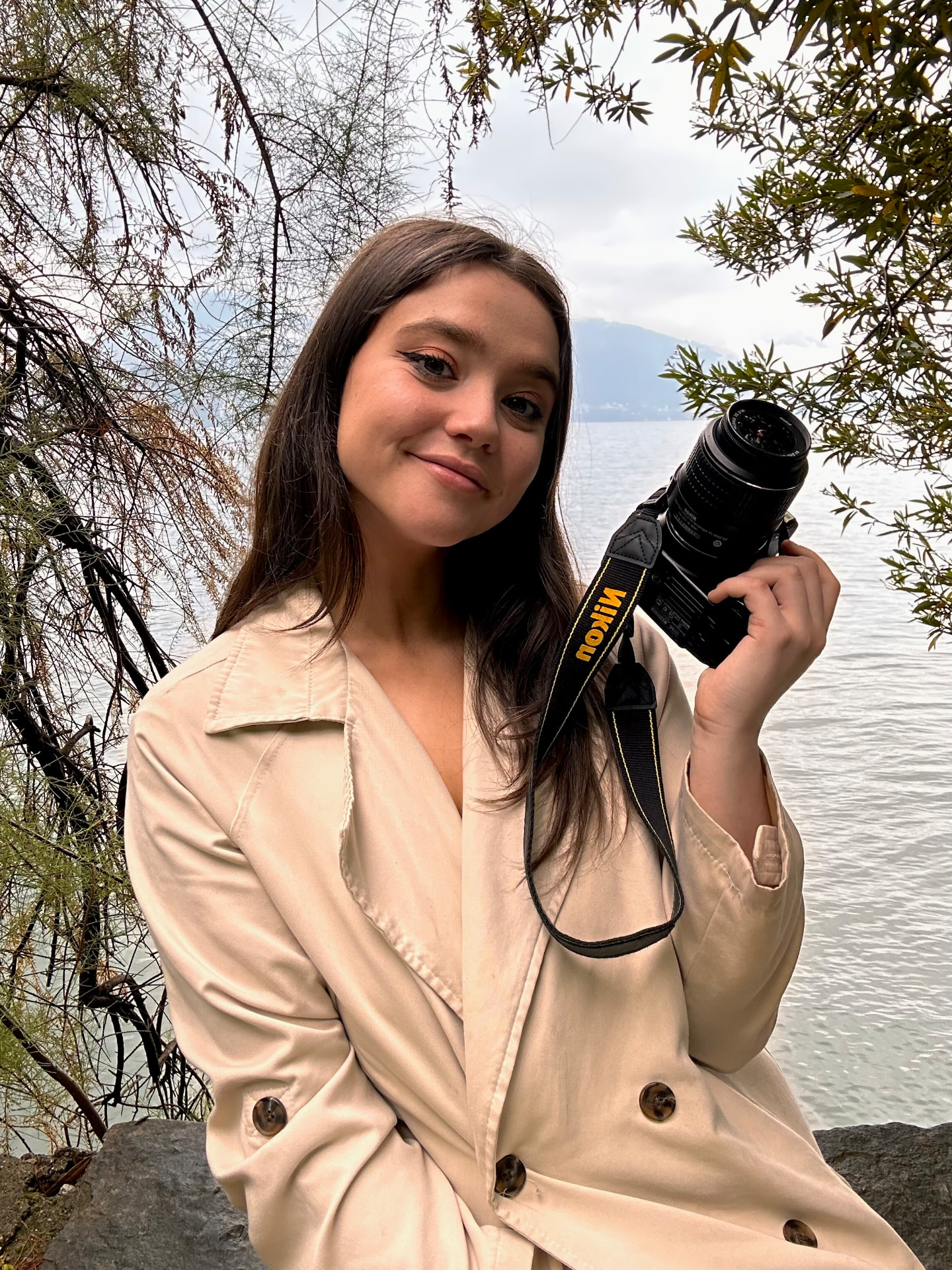 Aurore, photographe, tenant son appareil près d'une fenêtre